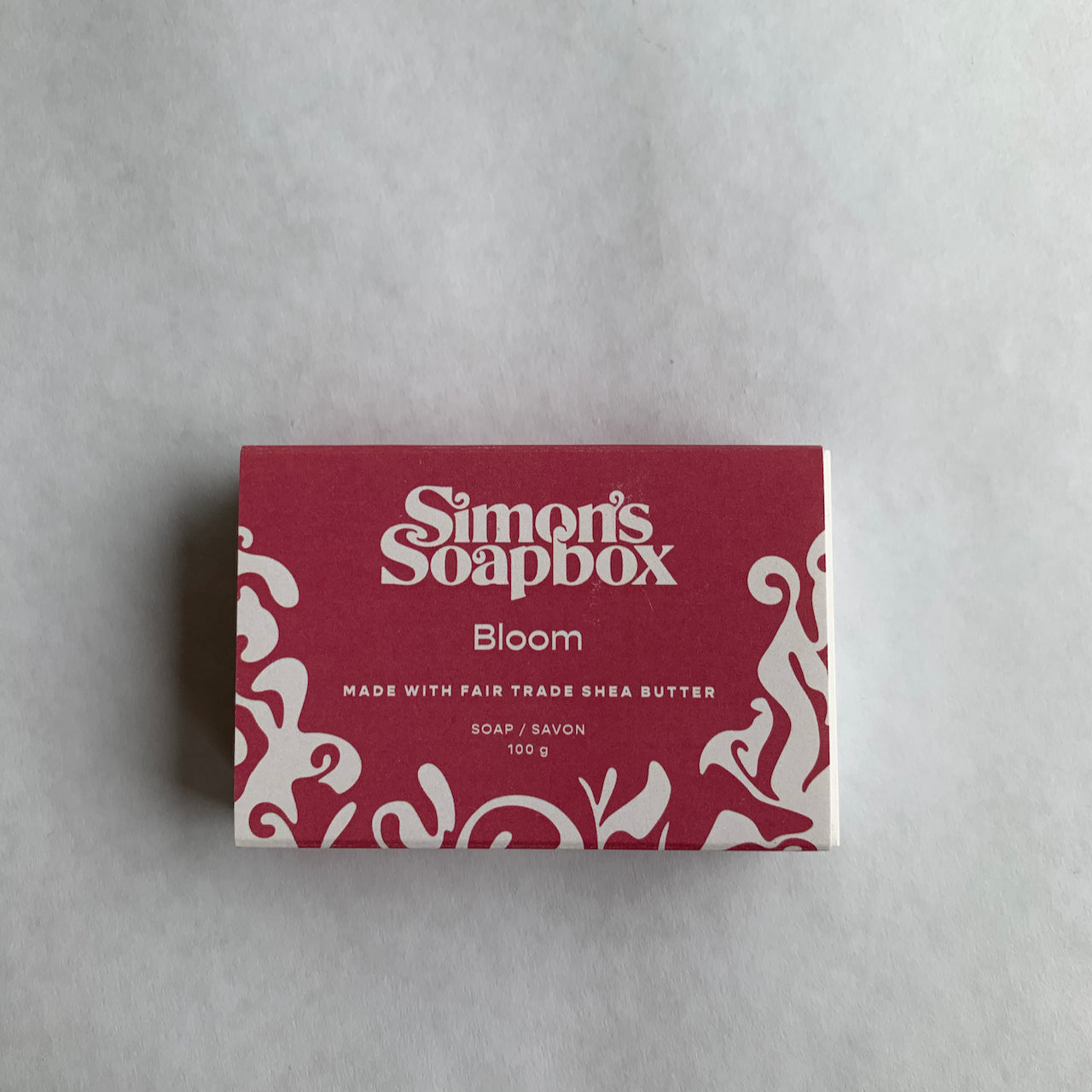 pink package that reads Simon's Soapbox Bloom made with fair trade shea butter 100 g